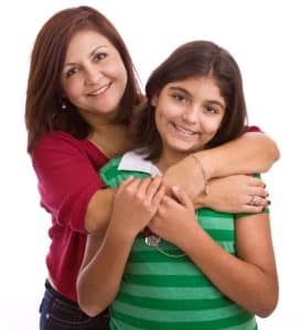 Mother and daughter smiling and hugging.